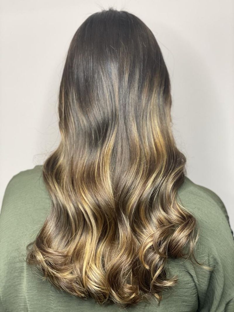 Woman with balayage hair featuring caramel and honey highlights
